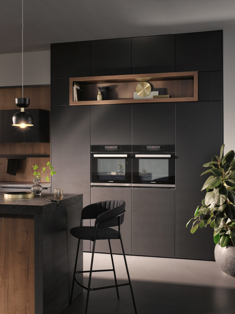 Cocina de diseño con muebles hasta el techo y estantería de madera decorativa