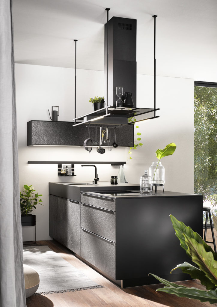 Cocina de acabados oscuros com campana decorativa