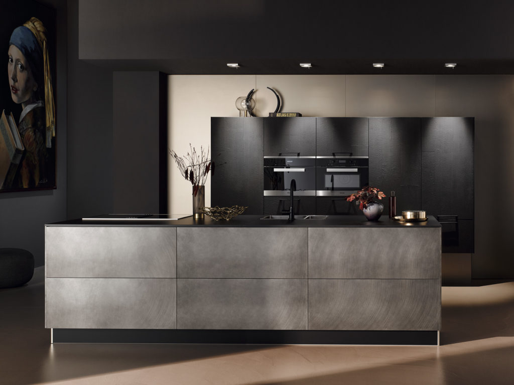 Cocina minimalista de acabado gris oscuro y negro con textura. Cocina con isla de diseño hecha a medida.