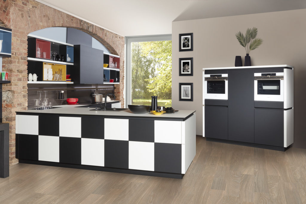 Divertida cocina con sistema de estantería multicolor y península en blanco y negro.
