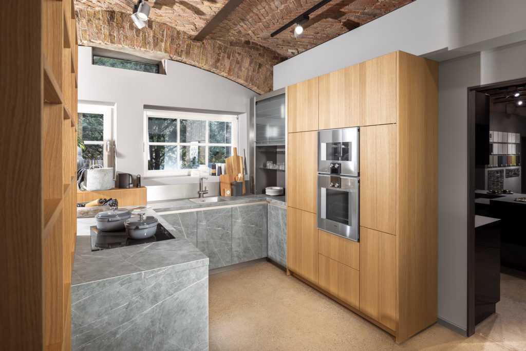 Cocina pequeña en forma de U de acabado madera clara y verde texturizado