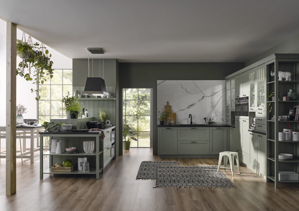 Cocina clásica con mueble de color verde menta y tirador corto. Cocina con encimera negra de concepto abierto.