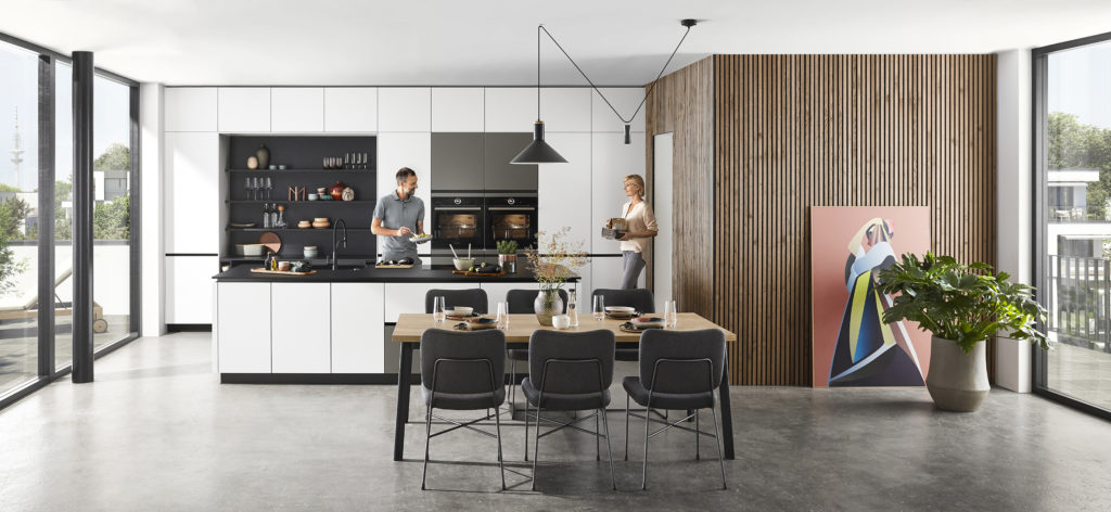 Pareja preparando la comida en cocina moderna